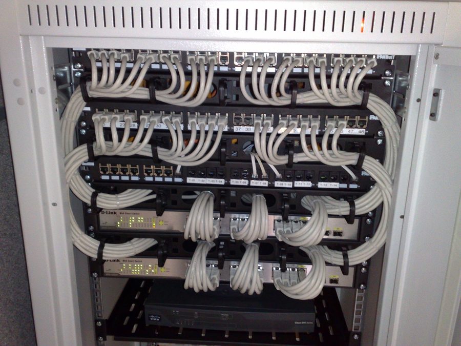 A comms cabinet with patch panels, switches and structured cabling